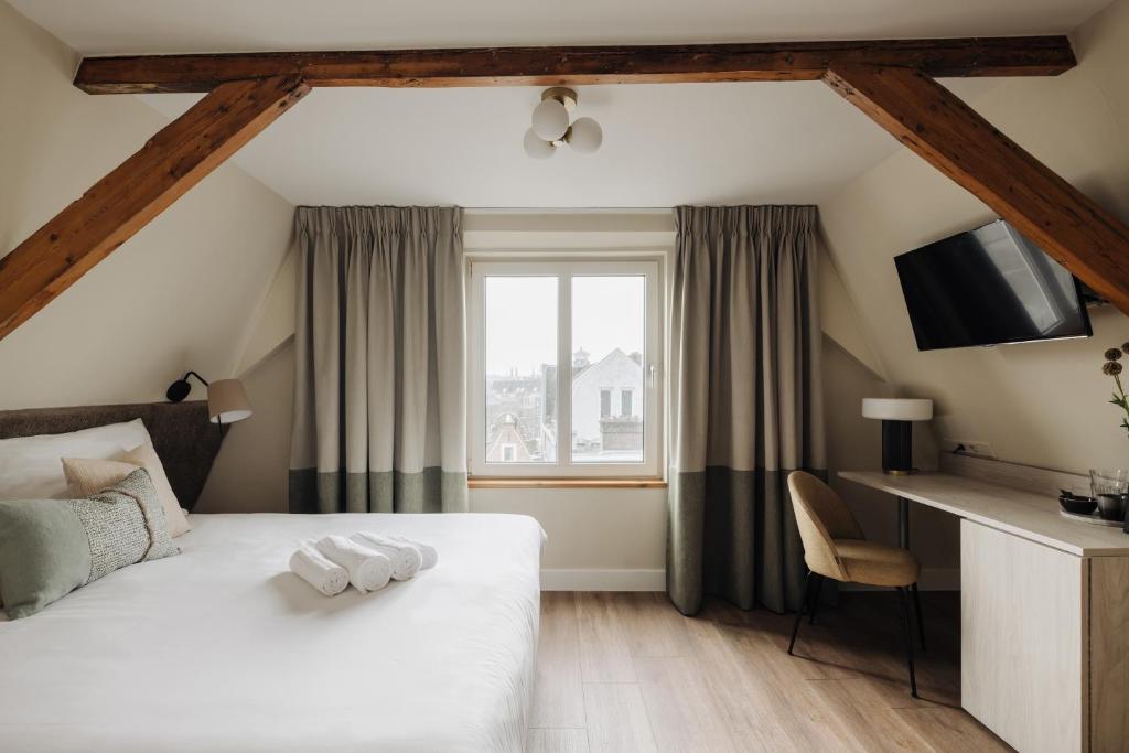 a hotel room with a bed and a window at Adam Suites Hotel in Amsterdam