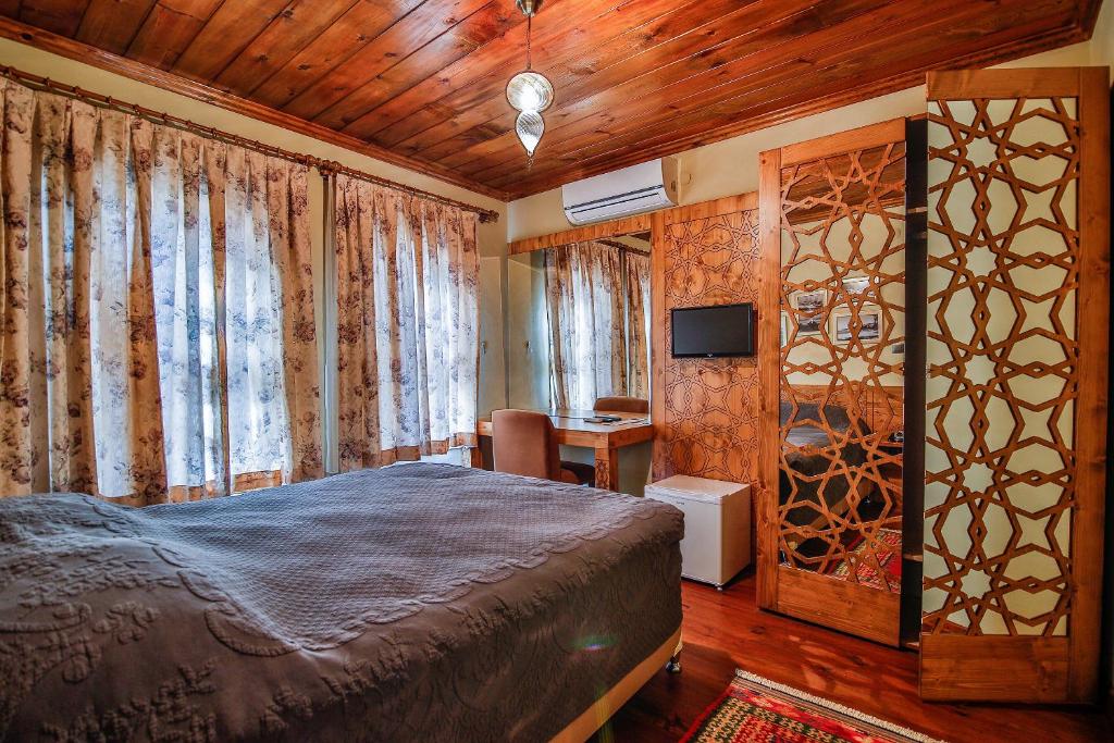 1 dormitorio con 1 cama y TV en Kum Butik hotel en Amasra