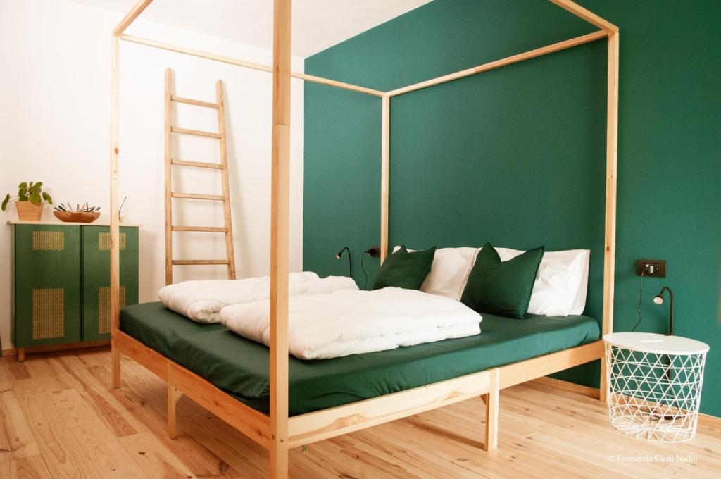 a bedroom with a canopy bed with a ladder at Foresteria Cà di Nadin in Carriola