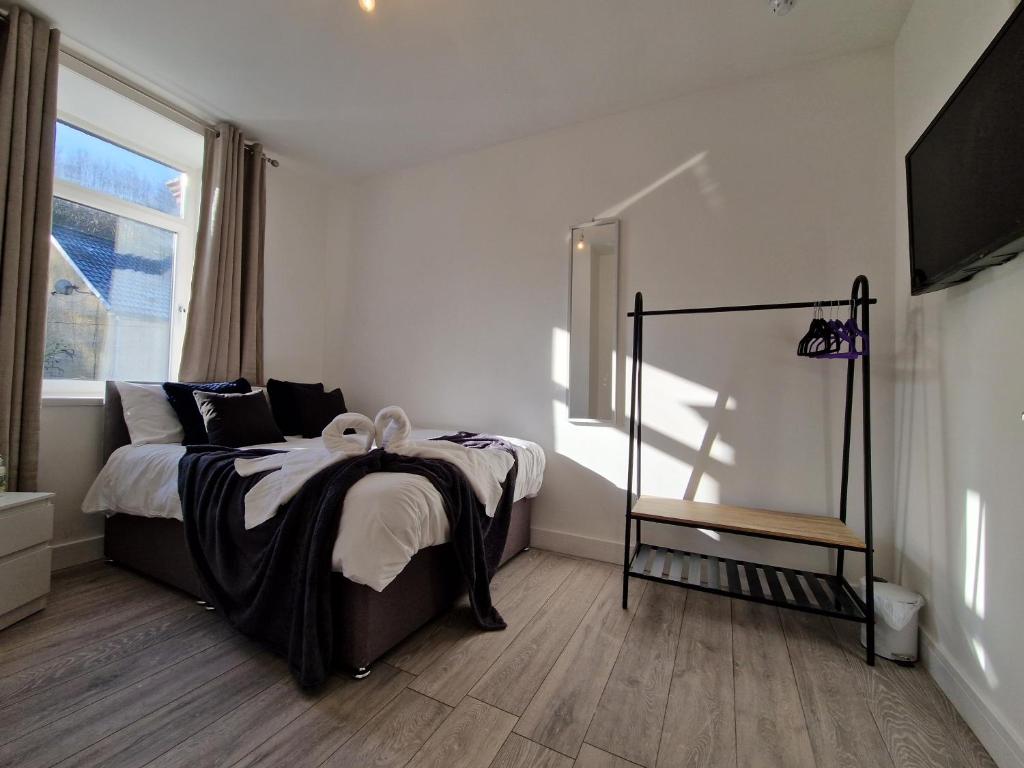 a bedroom with a bed and a window at Flat 3. Modern one bed apartment, Tynte Hotel, Mountain Ash in Quakers Yard