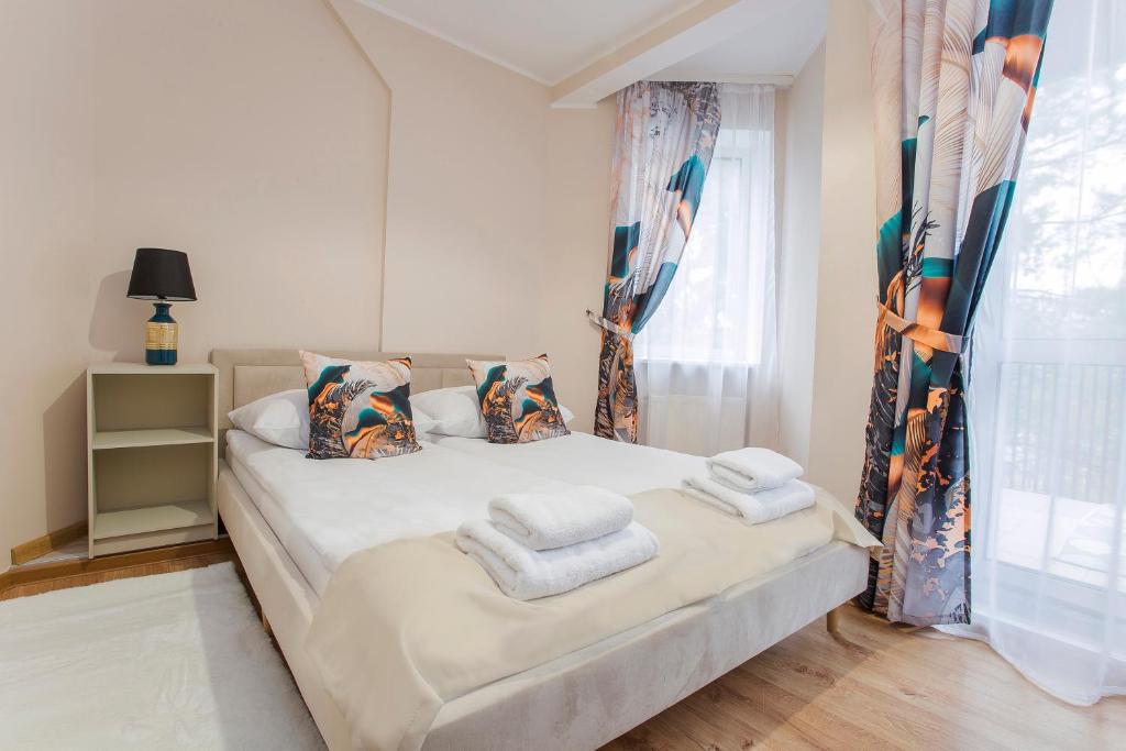 sypialnia z łóżkiem z ręcznikami w obiekcie Willa Marcella w mieście Białystok