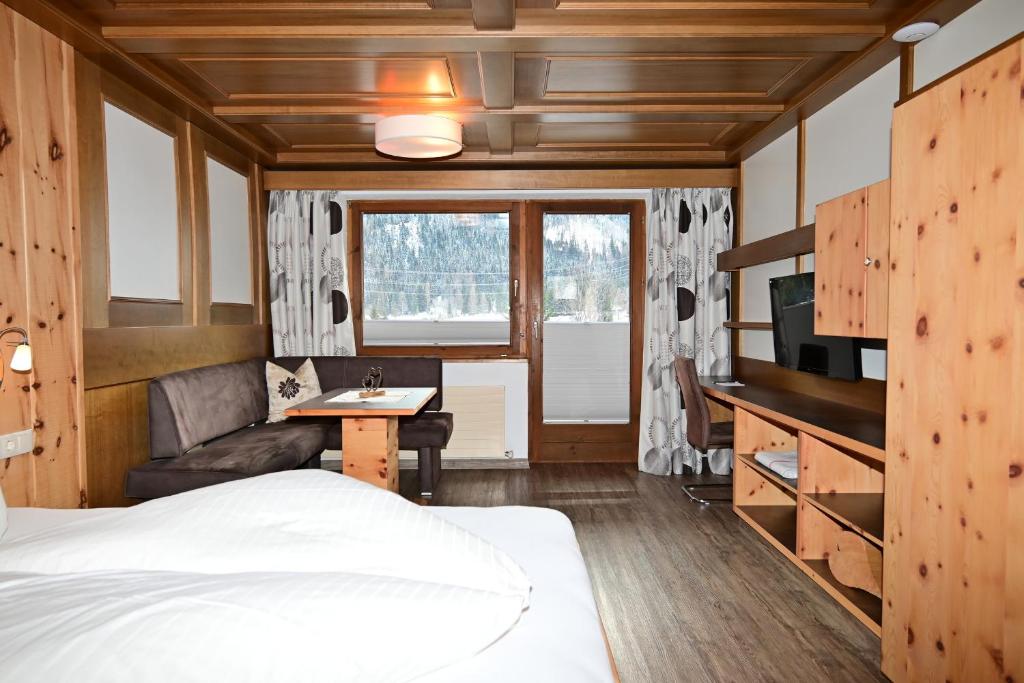 1 dormitorio con cama, escritorio y sofá en Zugspitze, en Biberwier