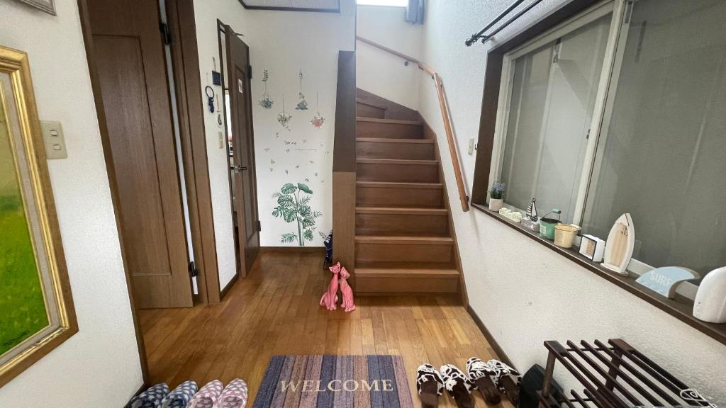 a hallway with stairs and shoes on the floor at ELM On The Beach in Kitaibaraki