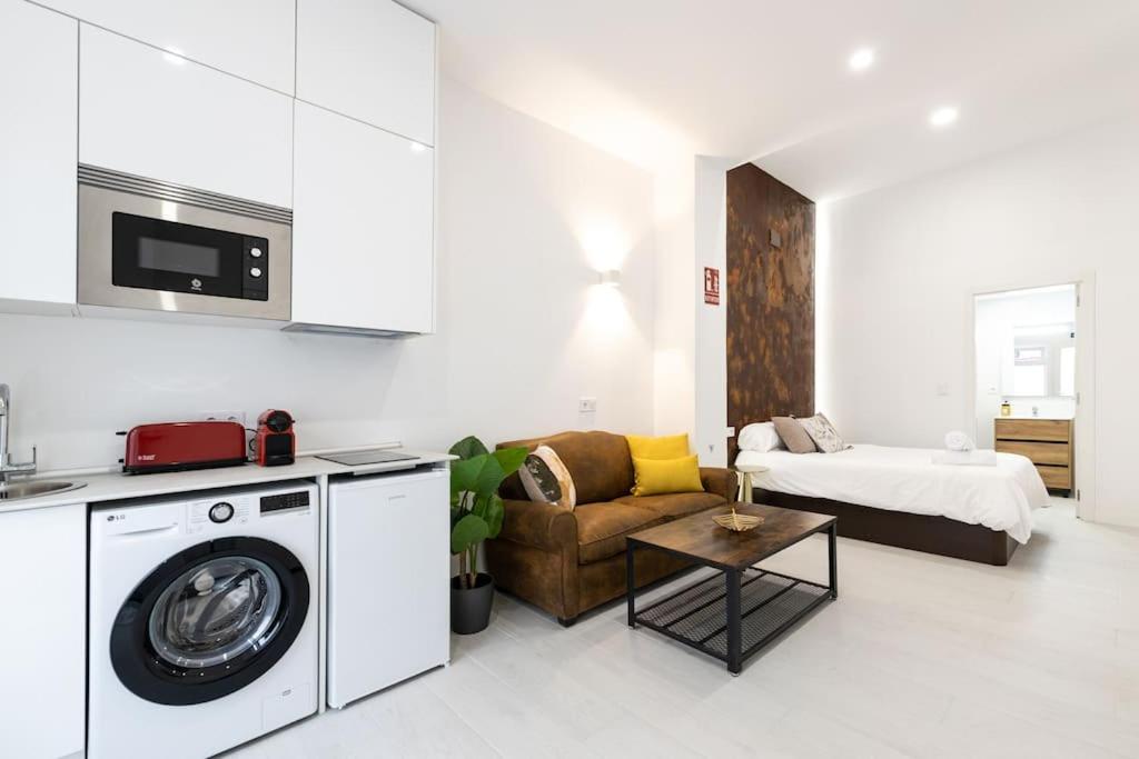 sala de estar con lavadora y sofá en Loft situado cerca del Santiago Bernabéu, en Madrid
