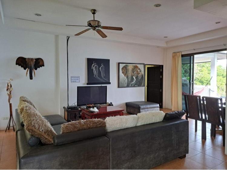 un soggiorno con divano e TV a schermo piatto di Ocean View Villa a Ko Tao