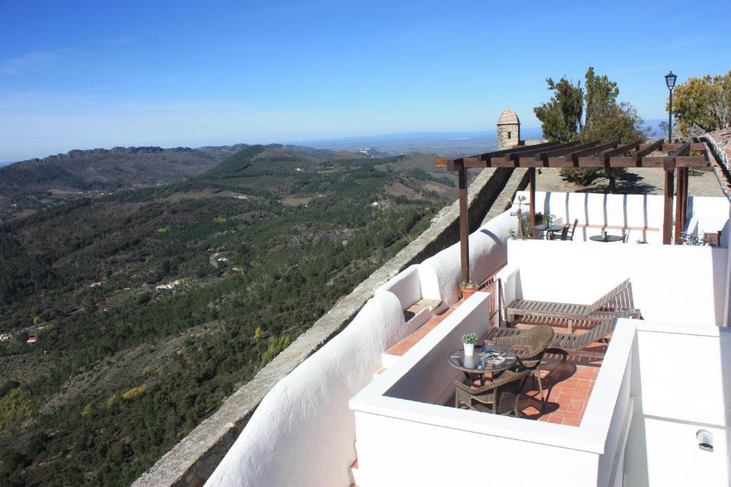 a balcony with a table and a view of the mountains at Dom Dinis Marvão in Marvão