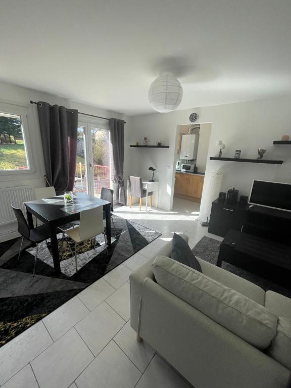 een woonkamer met een bank en een tafel bij Les Jonchères in Luxeuil-les-Bains