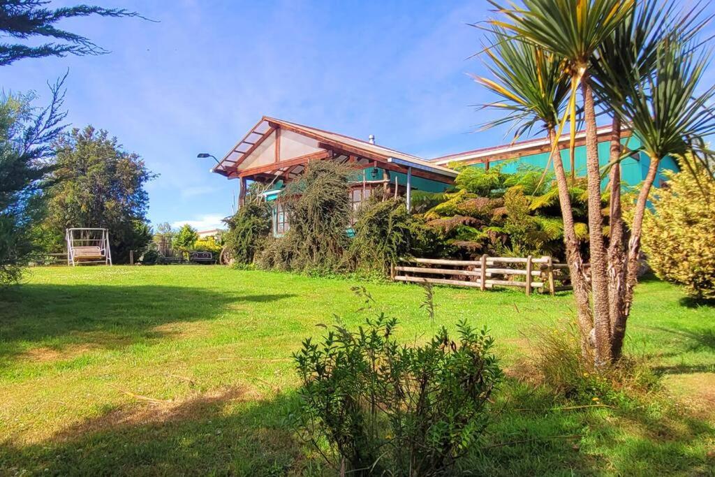 uma casa com uma palmeira em frente a um quintal em El Viloche - Casa de campo con tinaja em Puerto Montt