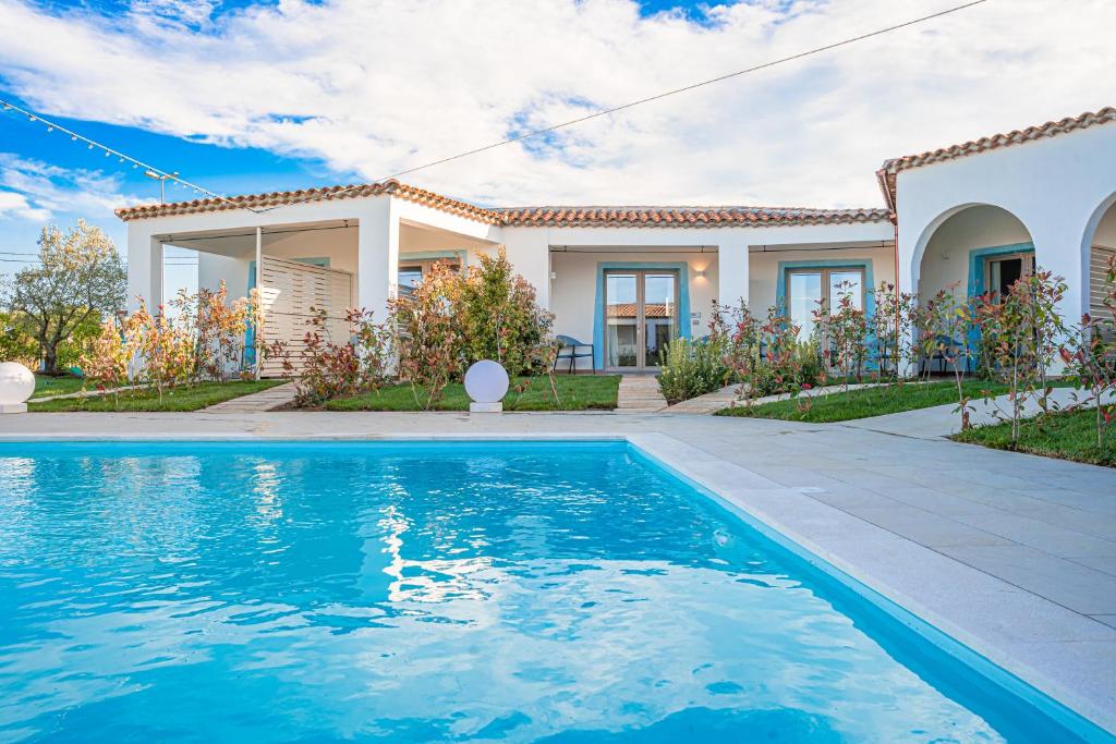 Villa con piscina frente a una casa en AQUA SARDINIA boutique hotel en Budoni