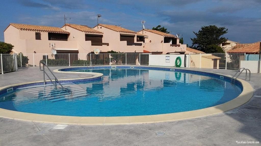 una gran piscina de agua azul frente a una casa en 746 Aphrodite naturiste, en Leucate