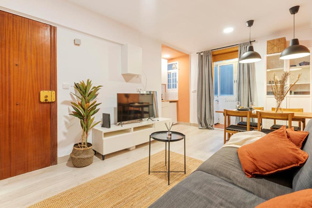 a living room with a couch and a tv at Lodging Apartments Barceloneta Mar in Barcelona