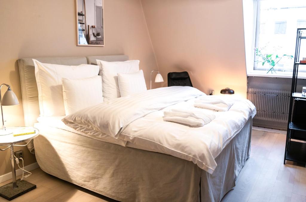 a bedroom with a large bed with white sheets and pillows at The Duxiana Malmö in Malmö