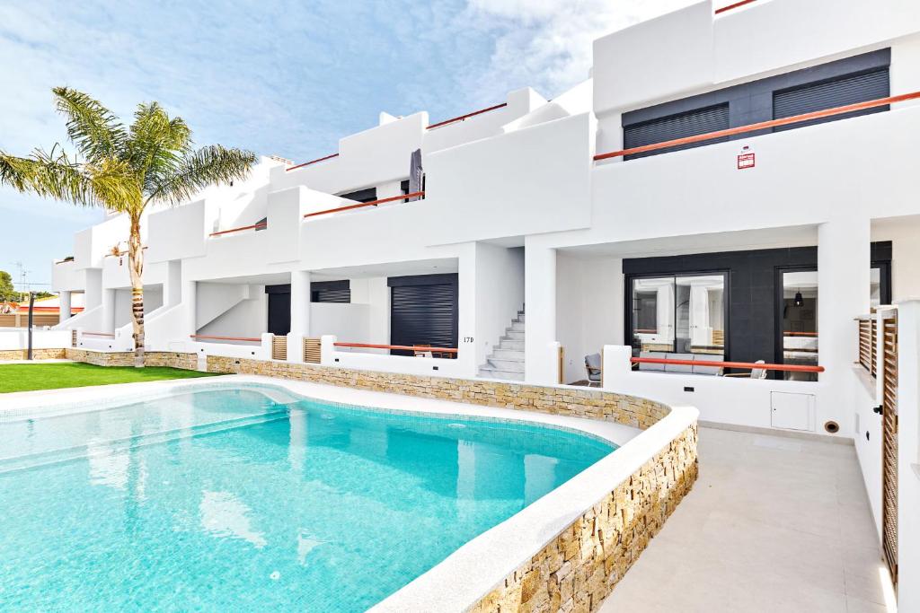 une maison avec une piscine en face de celle-ci dans l'établissement Apartment Tropical Beach, à San Javier