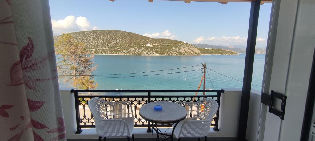 balcón con mesa, sillas y vistas al agua en Vasilis Apartments, en Ermioni