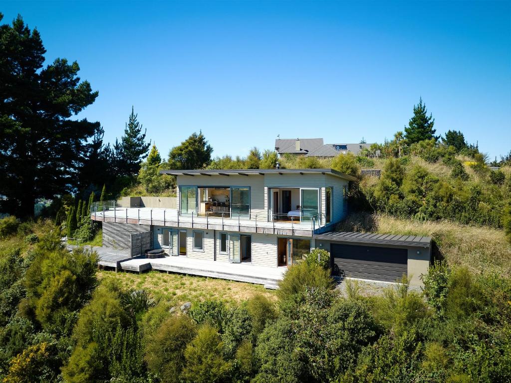 a house on top of a hill with trees at Ata Rangi Lodge - Kaikoura Holiday Home in Kaikoura