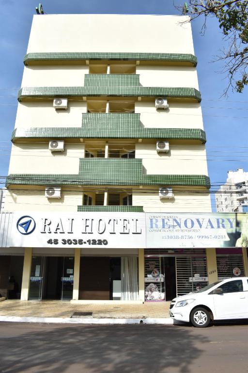 ein weißes Auto, das vor einem Gebäude parkt in der Unterkunft Rai Hotel - By UP Hotel - próximo a Prefeitura in Cascavel