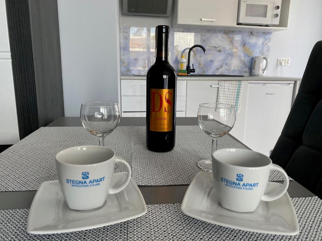 una botella de vino y dos copas de vino en una mesa en Stegna Apart en Stegna