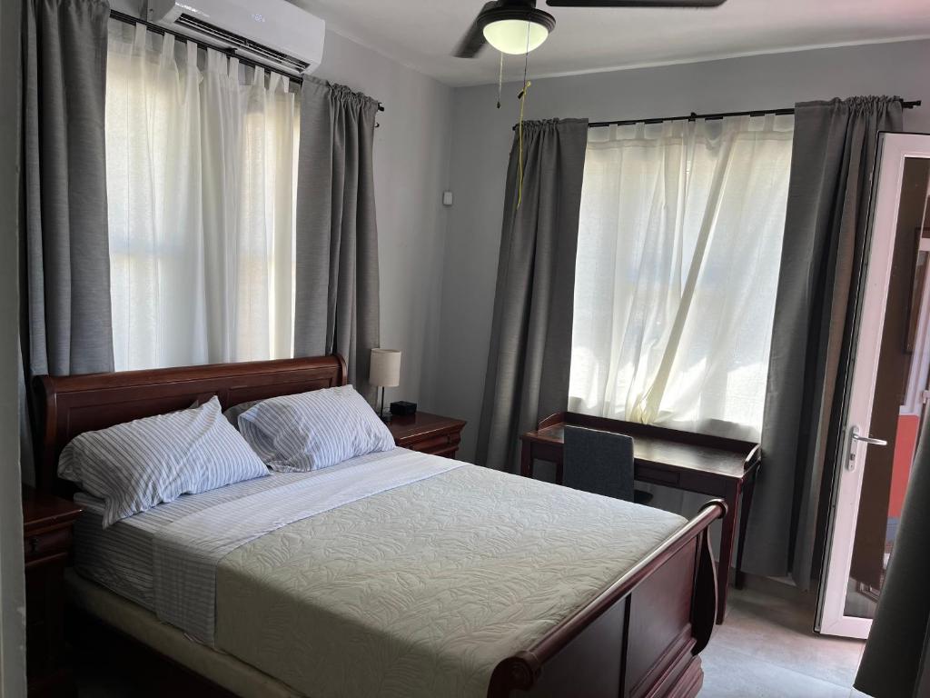 1 dormitorio con 1 cama, escritorio y ventanas en La Estancia Vacation Rentals, en San Juan