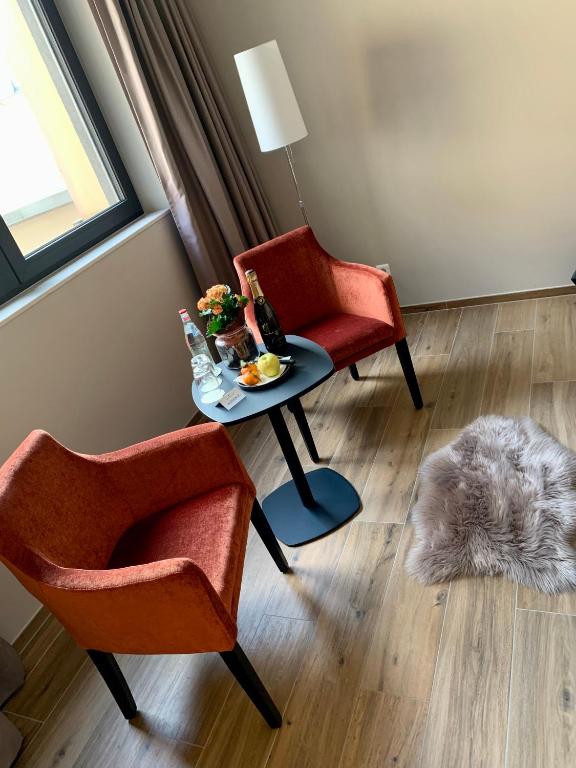 a living room with two chairs and a table at Hotel Monvillage in Mondercange