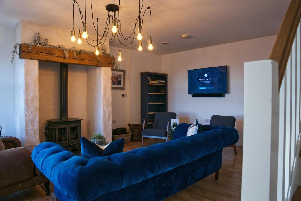 a living room with a blue couch and a fireplace at Irish Sea Cottage in Annalong