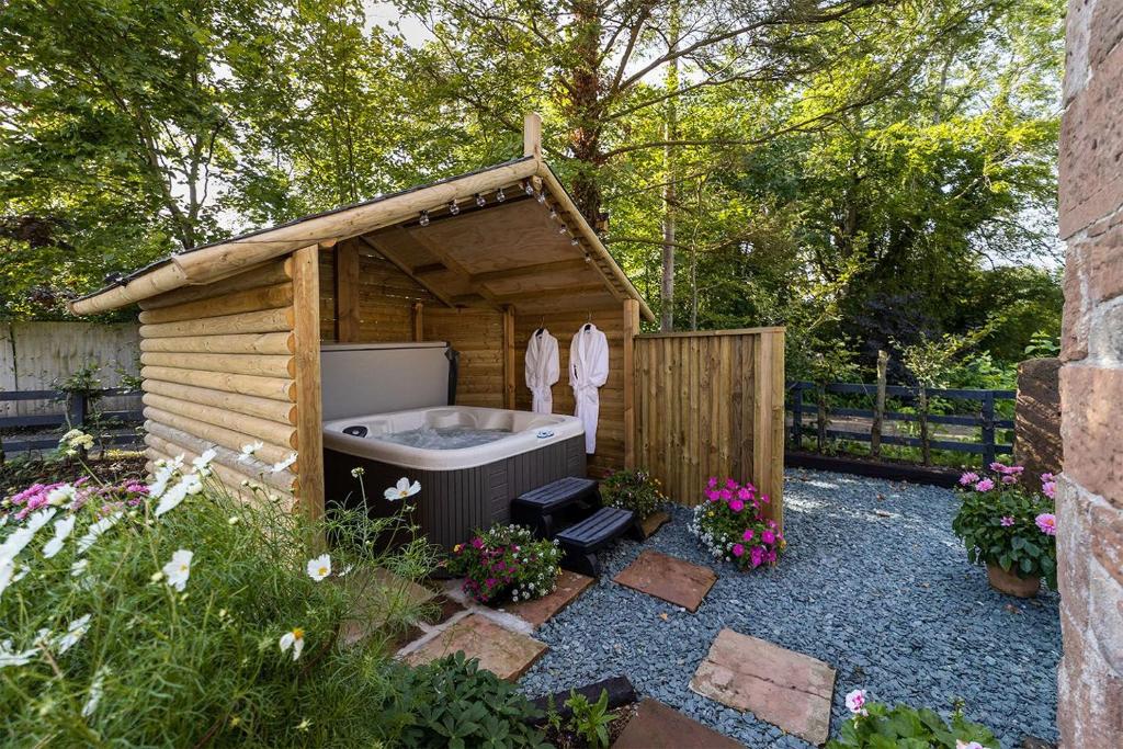 bañera grande en un cobertizo de madera en Daisy Cottage, Dalston, Nr Carlisle, en Carlisle