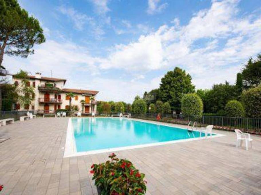 a swimming pool in front of a house at House Dogana in Peschiera del Garda
