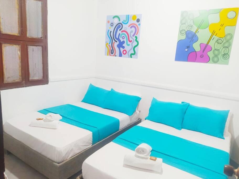 two beds in a room with blue and white at Apartamento - Centro Histórico 209 San Agustin in Cartagena de Indias