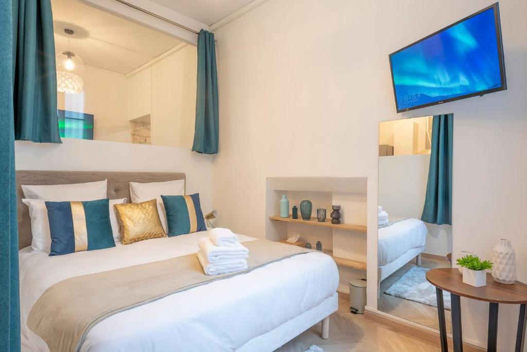 une chambre avec un grand lit blanc et un miroir dans l'établissement Bohemian Flat - Lovely Marais, à Paris