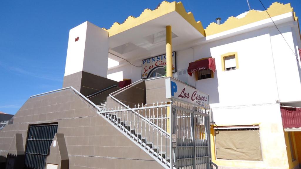 een witte kerk met een poort ervoor bij Pension Los Cisnes in Puerto de Mazarrón