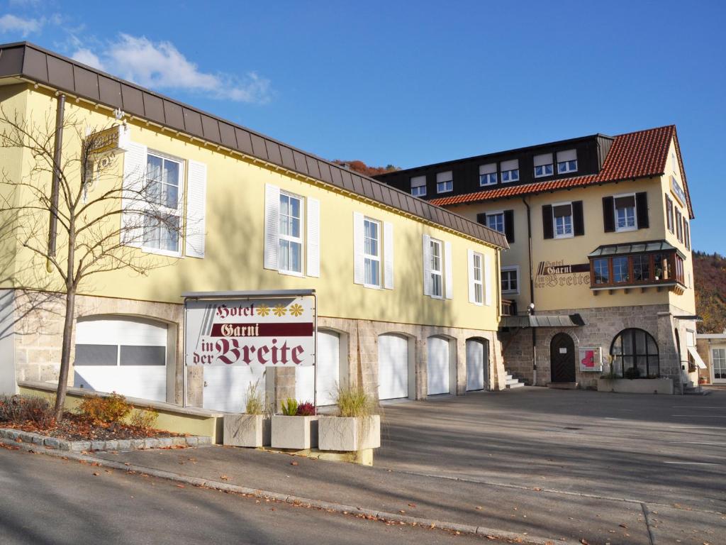 a yellow building with a sign in front of it at Hotel Garni in der Breite in Albstadt