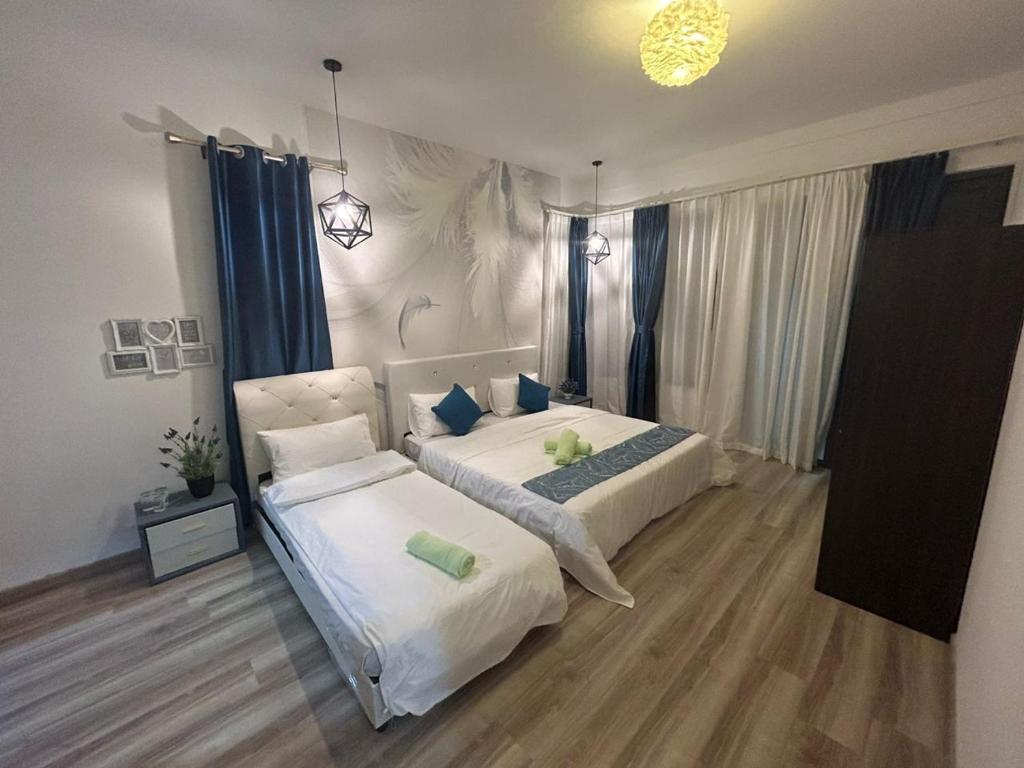 古晉的住宿－P' Residence Condo, Batu Kawa, Kuching，一间卧室配有两张带蓝色枕头的床