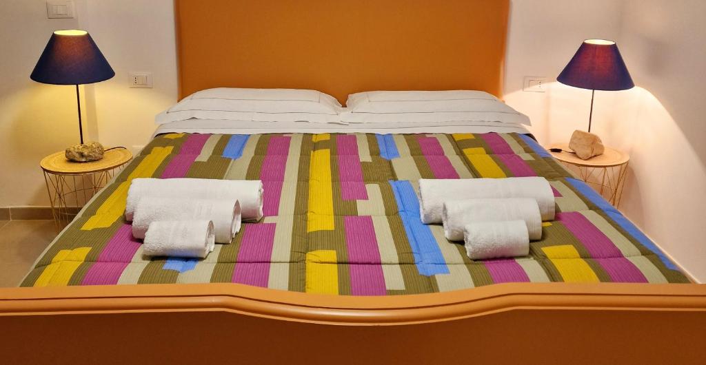 a large bed with two pillows on it with two lamps at Dimora Deva in Pescara