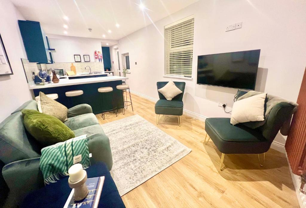 a living room with a couch and chairs and a flat screen tv at Gorgeous Newly Renovated 2 Double Bed Flat in Swansea