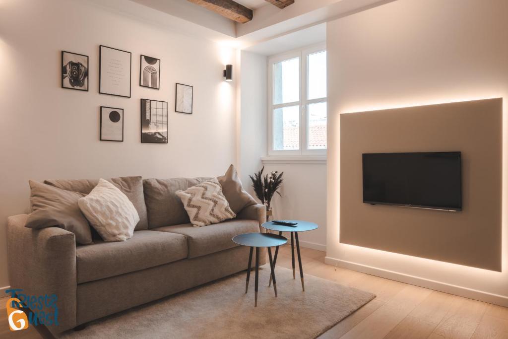 uma sala de estar com um sofá e uma televisão na parede em Michael&Renate - Stylish studio em Trieste