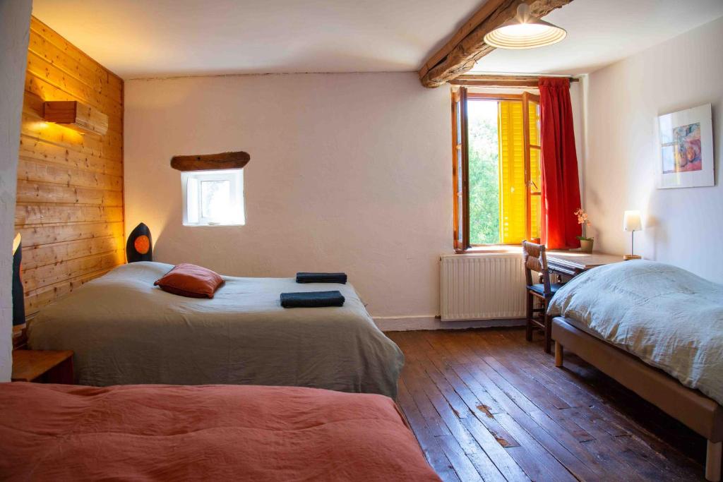 una camera con due letti e una finestra di Les Soleils a Mérinchal