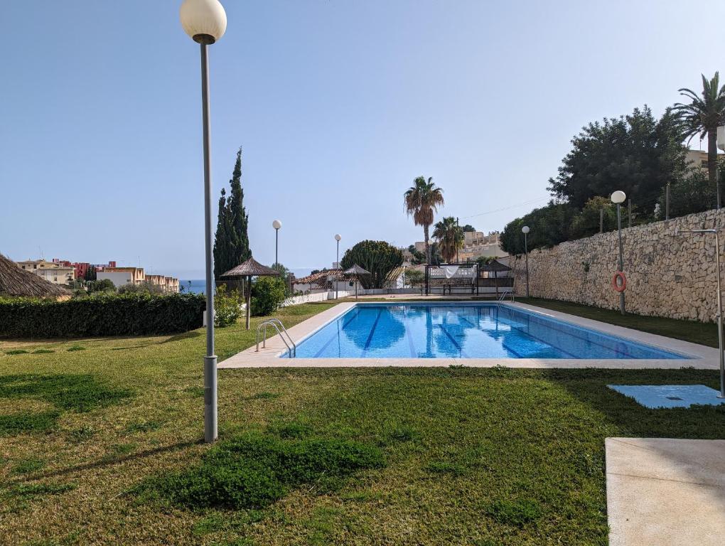a swimming pool in a park with a light pole at Apartment Mar Augusta in Calpe