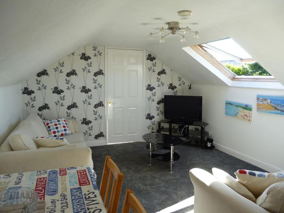 een woonkamer met een bank en een tv bij Poppy's Place Annex in Camelford North Cornwall in Camelford
