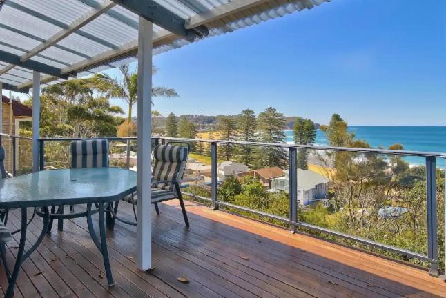 a balcony with a table and chairs and the ocean at Family Beach Retreat in Lovely Terrigal Home in Terrigal