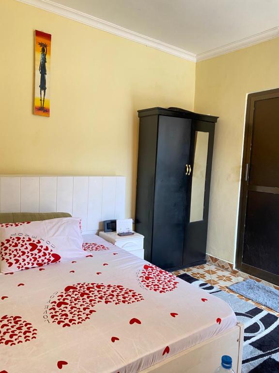 Cozy studio apartment في أروشا: غرفة نوم مع سرير وخزانة سوداء