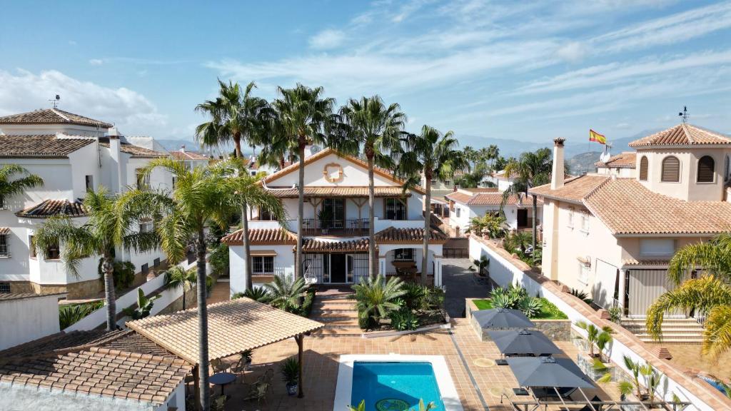 z góry widok na ośrodek z palmami i basenem w obiekcie Casa Limon, boutique Bed and Breakfast, Andalucia w mieście Alhaurín el Grande