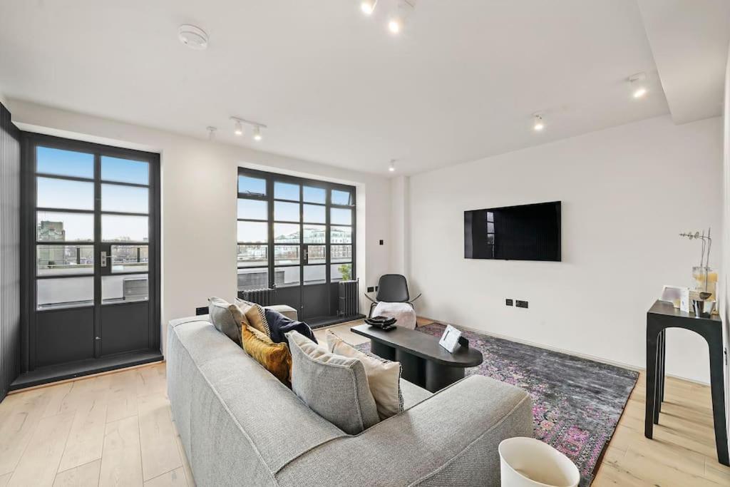 a living room with a couch and a tv at Two Bedroom Flat in Kensington in London