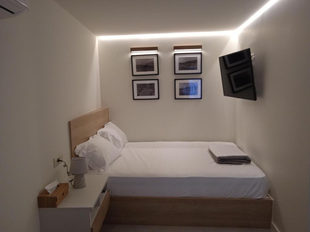 a bedroom with a bed and pictures on the wall at By The Sea - Paleros in Paleros