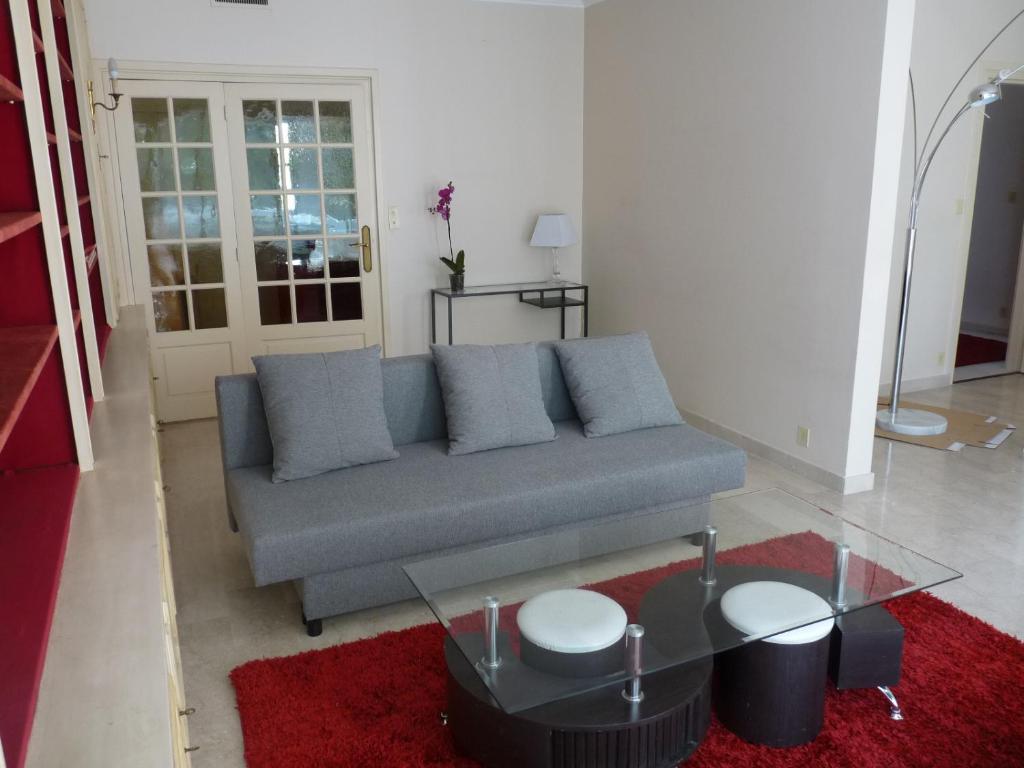 un salon avec un canapé et une table en verre dans l'établissement Appartement dans résidence Le Saint Pierre, à Avignon
