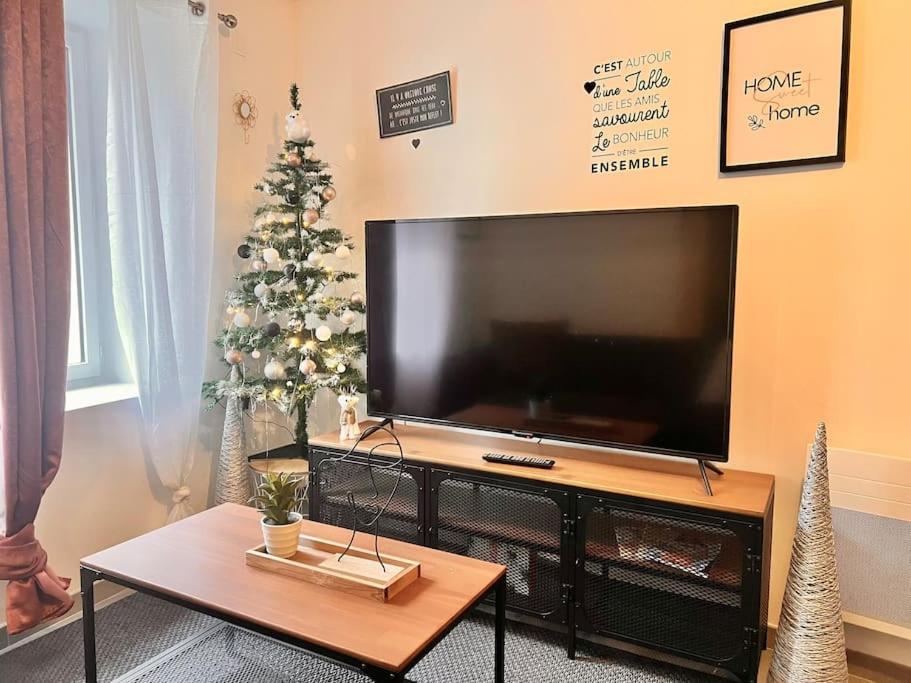 a living room with a television and a christmas tree at Jolie maison 2 chambres - CLIM MOBILE - TV - Proche d un lac in Ruelle-sur-Touvre