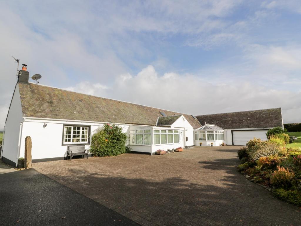 a large white house with a large driveway at Whiteside Cottage in Darvel