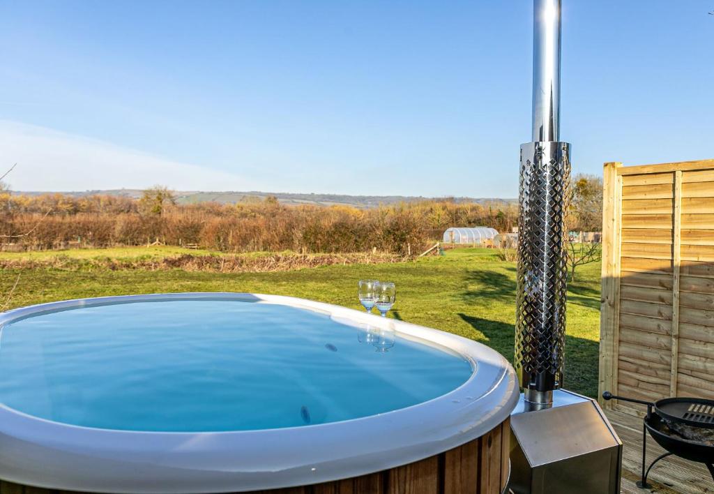 a jacuzzi tub in a yard with a patio at Kingston Black, Apple Tree Glamping, Nr Wells in Wells