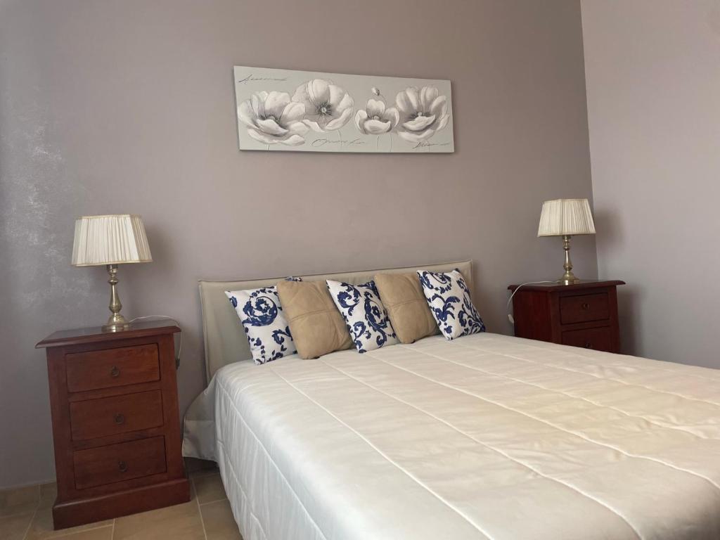 a bedroom with a large bed with two night stands at La casa di Flora aeroporto di Fiumicino in Fiumicino