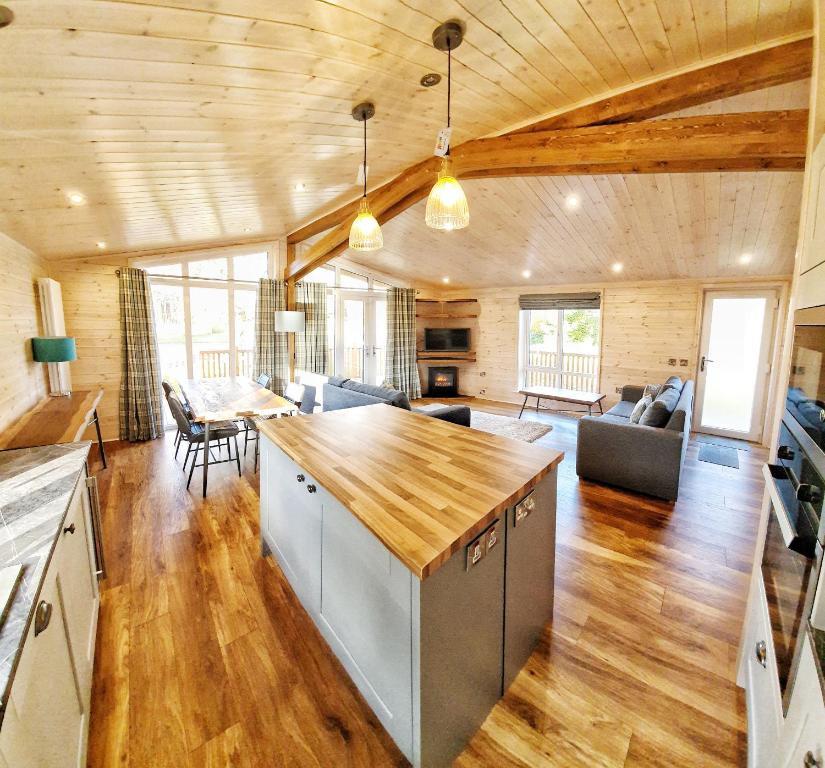 a kitchen and living room with a wooden ceiling at Skyline Lodge Loch Lomond Castle Lodges in Balloch