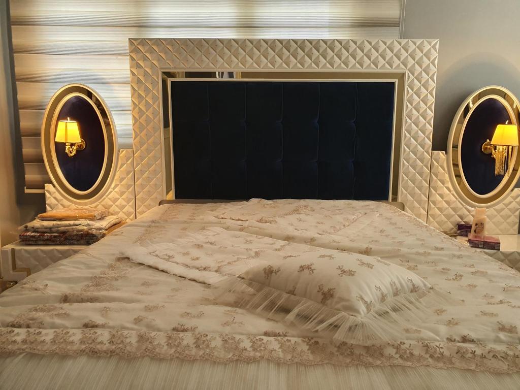 a bedroom with a large bed with two mirrors at Erzurum DAMAK GRUP in Erzurum
