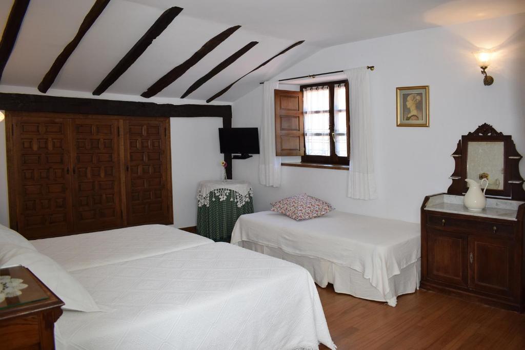 a bedroom with two white beds and a window at Habitaciones Casona De Linares in Selaya